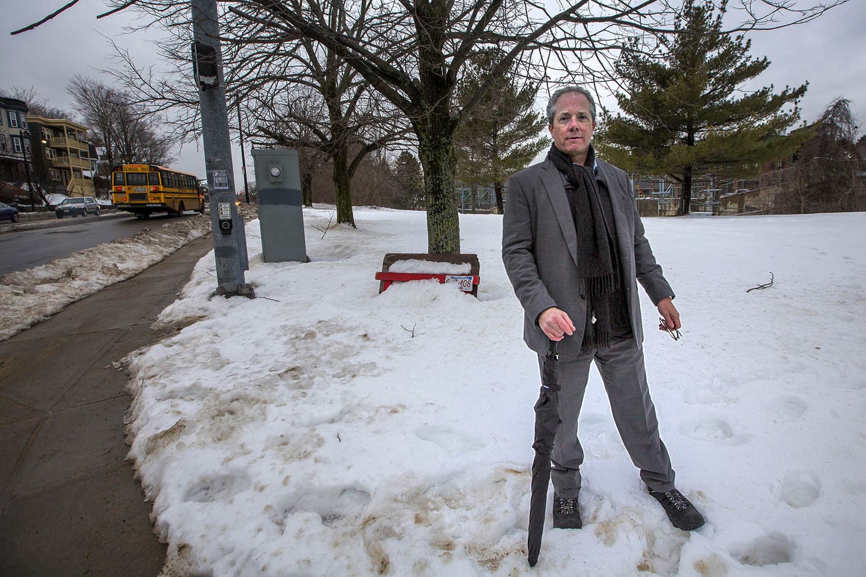 Bart Mitchell, CEO of Community Builders, Inc., stands on a parcel of land at the corner of Hyde Park Avenue and Ukraine Way in Jamaica Plain, where a 78-unit mixed-income housing development has been stalled. (Jesse Costa/WBUR)