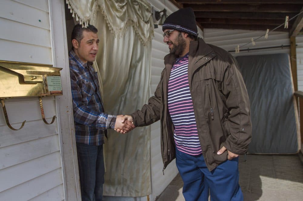 Zid bids farewell to his friend and next-door neighbor, Mohammed Sousa, after he stopped by. Sousa is also a Syrian refugee who has resettled in Westfield. (Jesse Costa/WBUR)