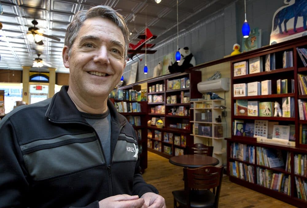 Peter H. Reynolds, owner of The Blue Bunny Bookstore in Dedham stands surrounded by books on the day Amazon also opened a bookstore in the town. (Robin Lubbock/WBUR)