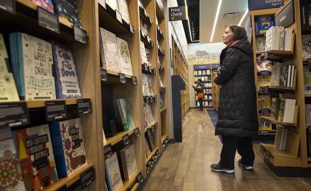 Opening day customer Susan Crowley, of Westwood, looks along the shelves at the new Amazon bookstore in Dedham. &quot;It's fun to browse,&quot; she says. (Robin Lubbock/WBUR)