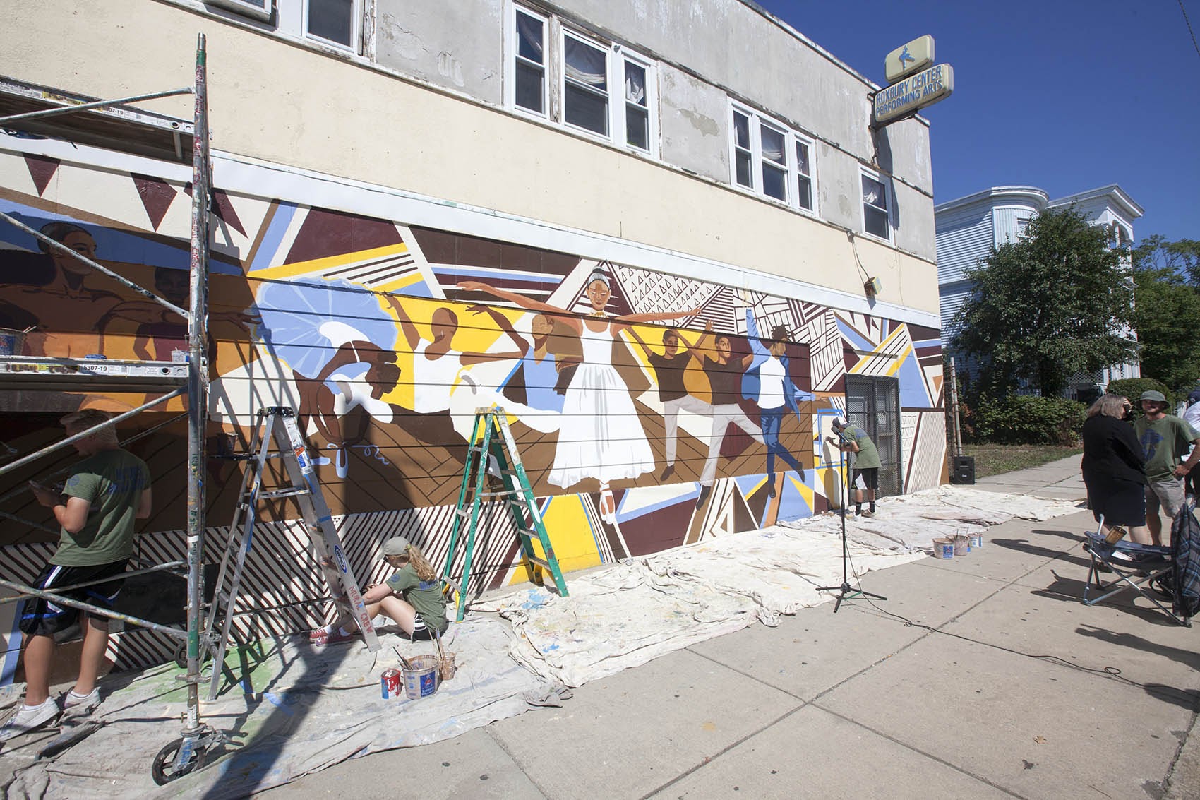 The mayor’s mural crew paints the Roxbury Center for Performing Arts last summer. (Joe Difazio for WBUR.)