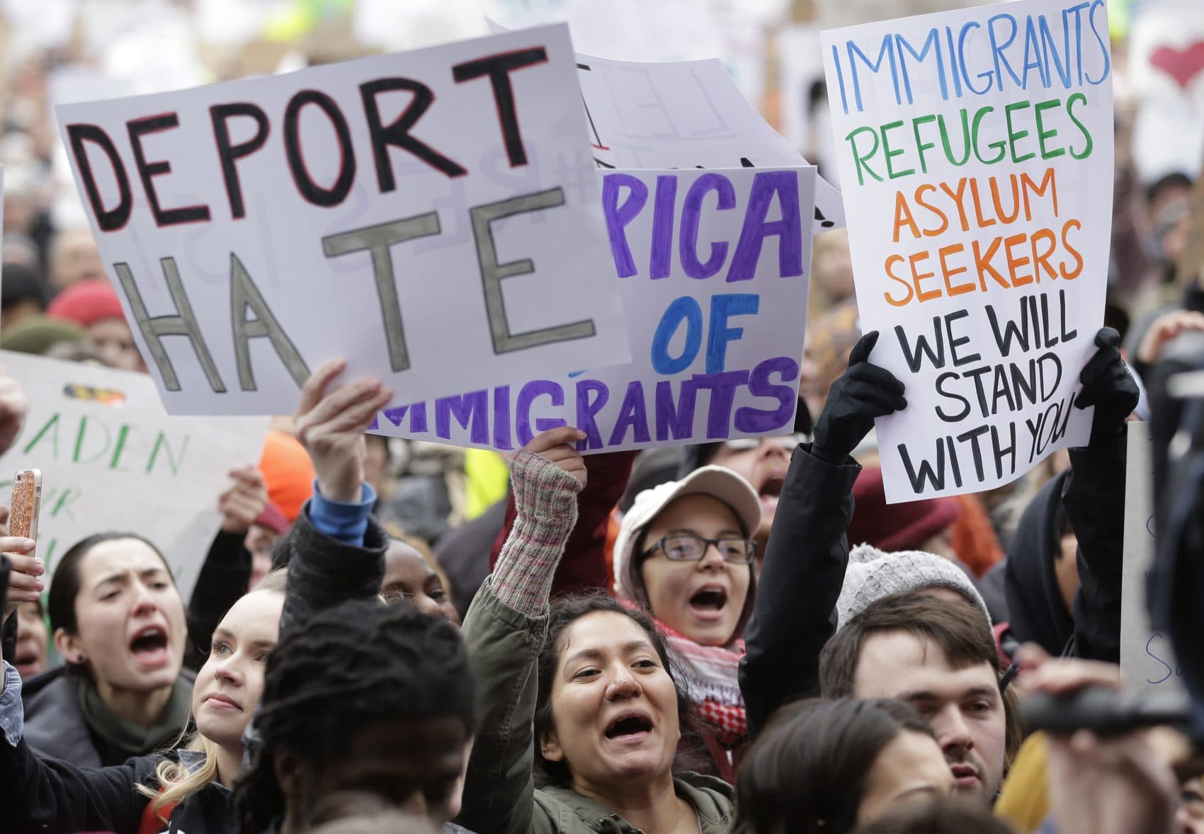 Demonstrators display placards in Boston on Jan. 29, 2017, during a rally against President Donald Trump's order that restricted travel to the U.S. (Steven Senne/AP)