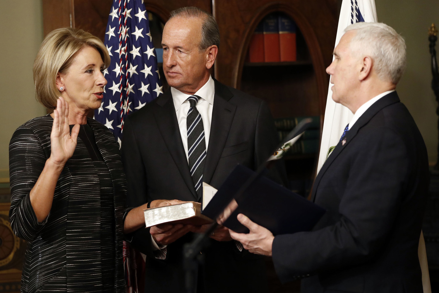 Vice President Mike Pence swears in Education Secretary Betsy DeVos in the Eisenhower Executive Office Building in the White House complex in Washington, Tuesday, Feb. 7, 2016, as DeVos' husband Dick DeVos watches. (AP Photo/Pablo Martinez Monsivais)