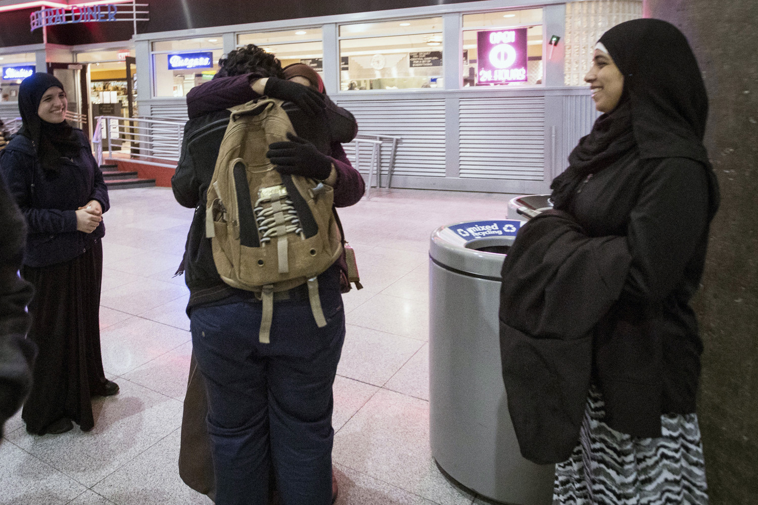 Ali Abdullah Alghazali, 13, from Yemen, center front, hugs his mother as his cousins looks on after he stepped out of an arrival entrance at John F. Kennedy International Airport, in New York. (Alexander F. Yuan/AP)