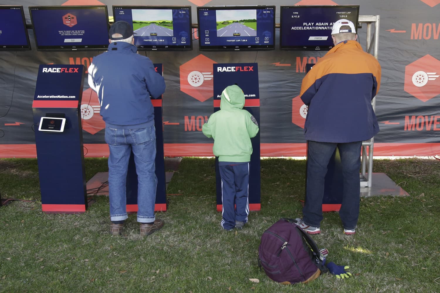 In this file photo, adults as well as kids enjoy a racing video game at the NASCAR Acceleration Nation interactive display at Daytona International Speedway. (John Raoux)