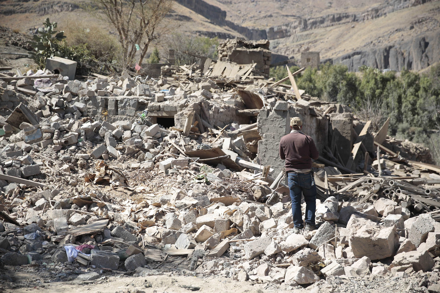 A man walks amid the rubble of a house destroyed by a Saudi-led airstrike on the outskirts of Sanaa, Yemen. (Hani Mohammed/AP)
