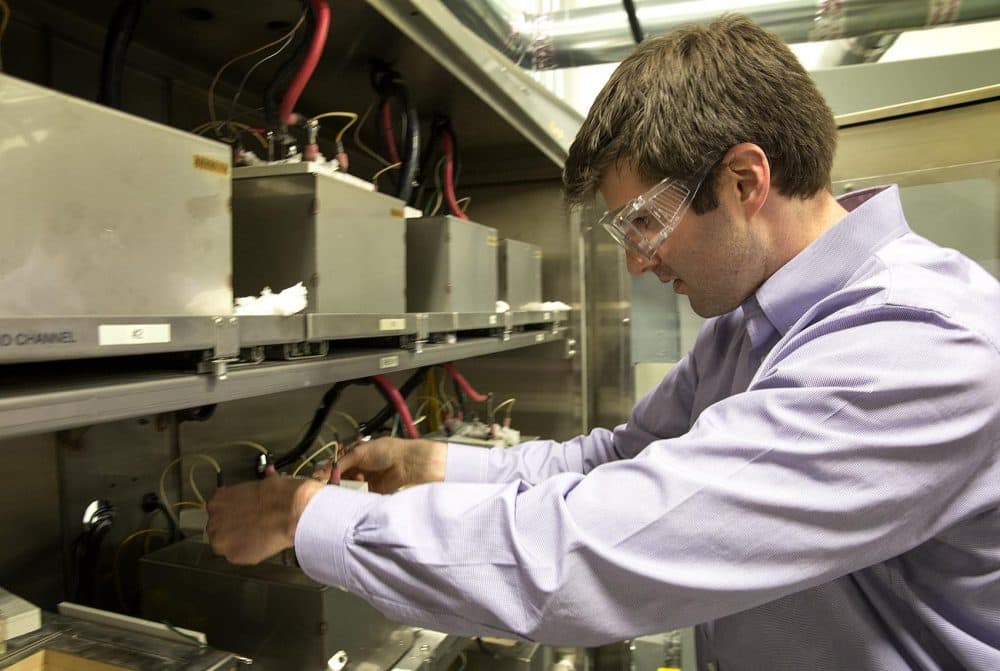 Ambri Chief Technology Officer Dave Bradwell places a battery into a testing rack. (Robin Lubbock/WBUR)