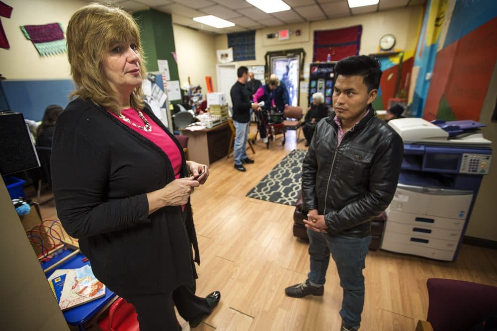 At the Community Economic Development Center in New Bedford Corinn Williams, left, assists a community member who has come in to inquire what he can do about being harassed on Facebook. (Jesse Costa/WBUR)