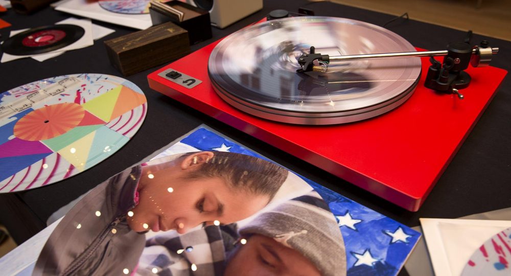 Vinyl spins on the &quot;Sound Lab&quot; turntable, surrounded by albums designed by students. (Robin Lubbock/WBUR)