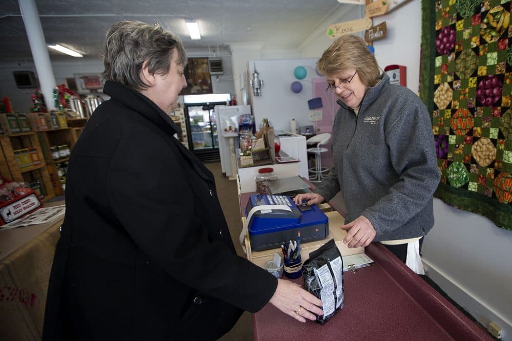 Beth Hunt, right, serves Winchendon local Jane Raymond at her recently opened store Not Just Produced. (Jesse Costa/WBUR)