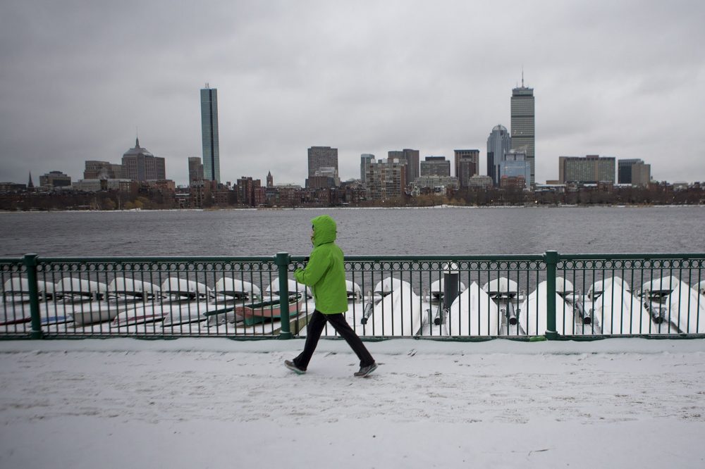 A woman gets a morning walk on Memorial Drive in early before the impending blizzard. (Jesse Costa/WBUR)