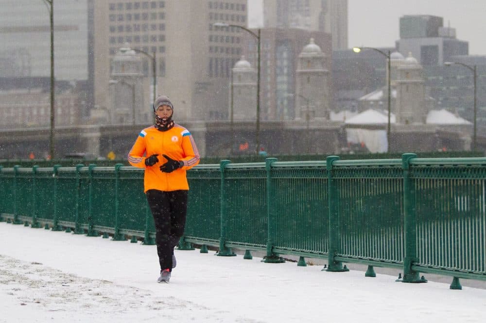 A runner on Memorial Drive as the snow begins to fall. (Jesse Costa/WBUR)
