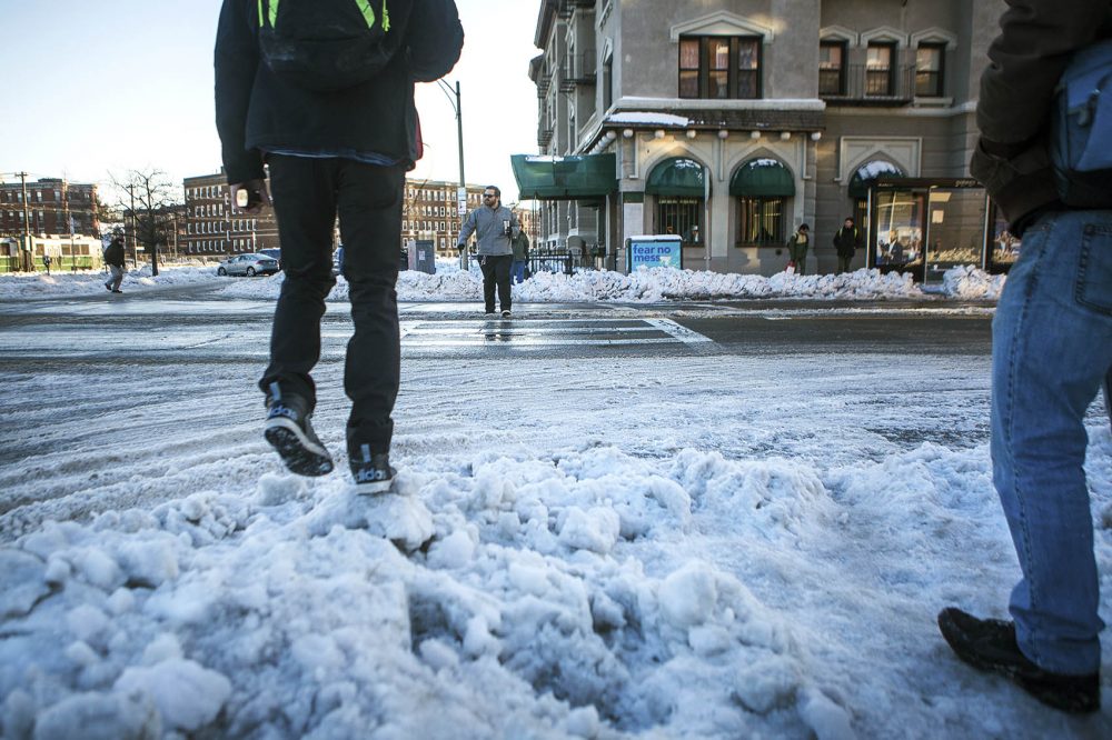 Pedestrians navigate treacherous icy conditions of the sidewalks on the corner of Commonwealth Avenue and Harvard Street Wednesday. (Jesse Costa/WBUR)