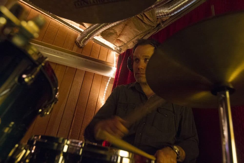 Drummer Tom Collins rehearses the rock opera in Medford. (Joe Difazio for WBUR)