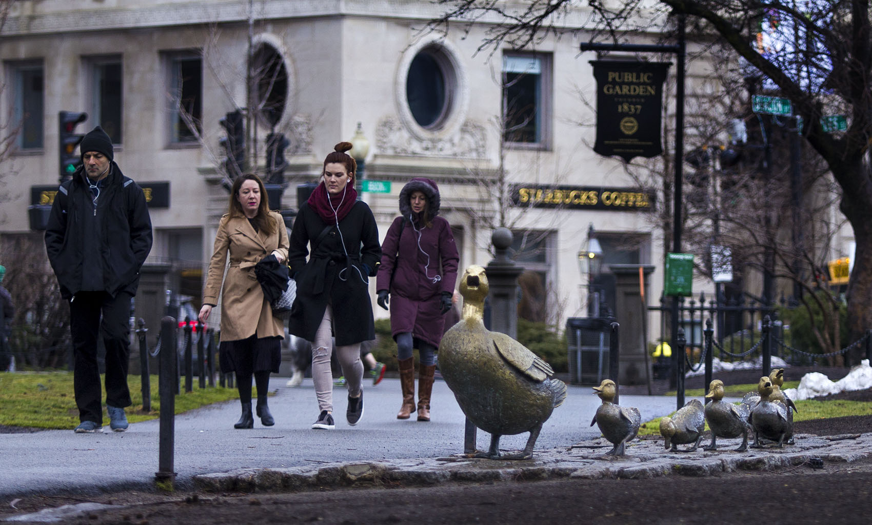 Pedestrians walking by the &quot;Ducklings&quot; in the Public Garden in Boston. (Jesse Costa/WBUR)