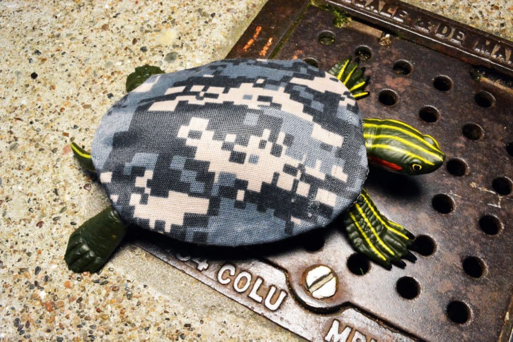 Military camouflage designed for urban combat allows reptiles to elude detection in cities as urbanization overtakes their natural habitats. In this model, a turtle wears a camouflage fabric shell covering. (Courtesy Jonathon Keats)