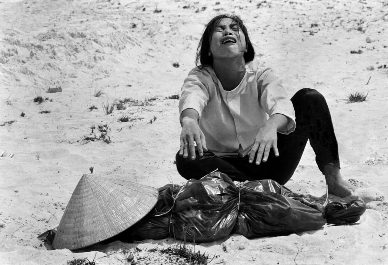 A woman mourns over the body of her husband after identifying him by his teeth, and covering his head with her conical hat. The man’s body was found with forty-seven others in a mass grave near Hue, April 11, 1969. The victims were believed killed during the insurgent occupation of Hue as part of the Tet Offensive. (Horst Faas/AP)