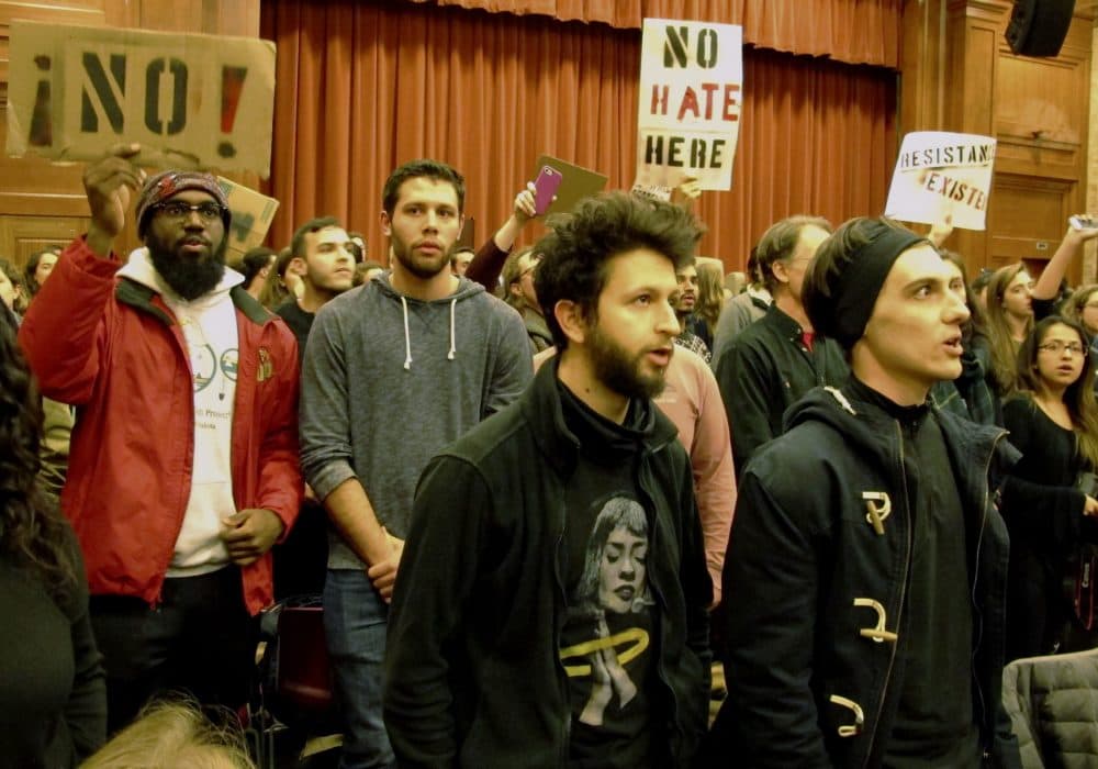 Middlebury College students turn their backs to Charles Murray, unseen, who they call a white nationalist, during his lecture in Middlebury, Vt., Thursday, March 2, 2017. Hundreds of college students on Thursday protested a lecture by a speaker they call a white nationalist, forcing the college to move his talk to an undisclosed campus location from which it was live-streamed to the original venue but couldn't be heard above protesters' chants, feet stamping and occasional smoke alarms. (AP Photo/Lisa Rathke)