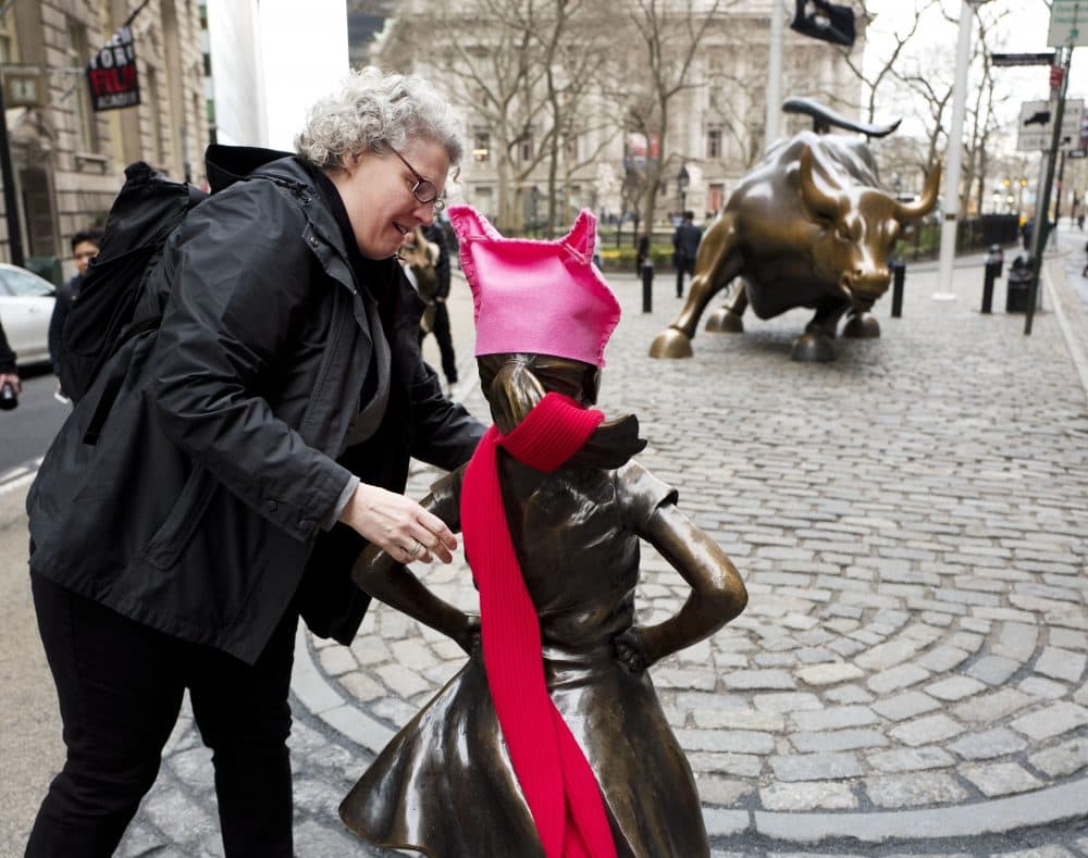 A woman places a red scarf on the statue. (Mark Lennihan/AP)