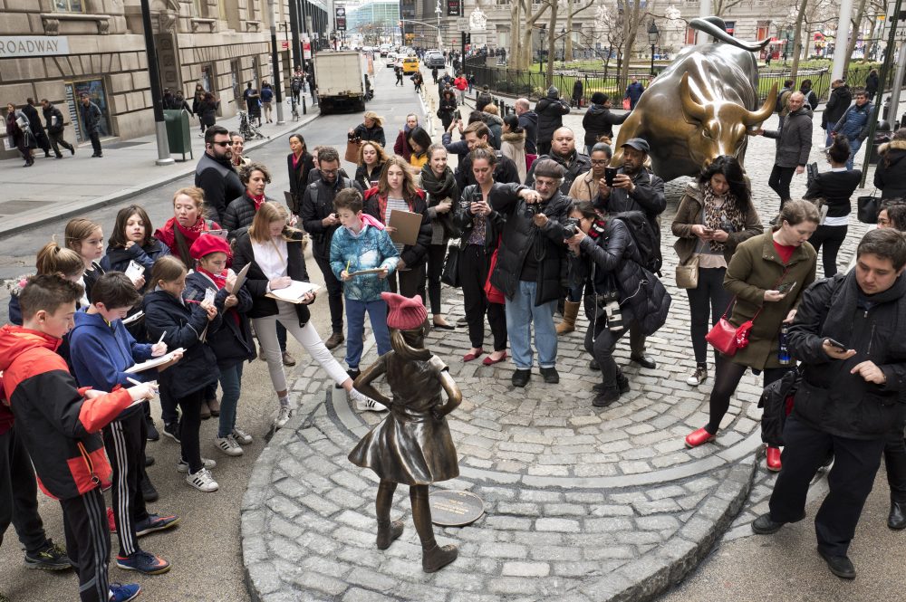 A crowd gathers around a statue of a fearless girl in New York City. (Mark Lennihan/AP)