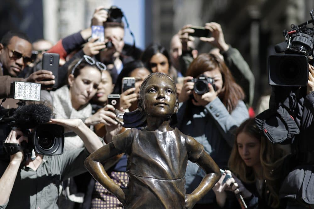 People flock to the new statue on Wall Street to take photos. (Mark Lennihan/AP)