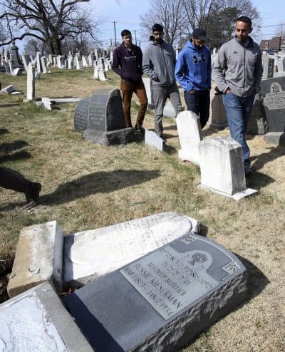 Volunteers from the Ahmadiyya Muslim Community survey damaged headstones at Mount Carmel cemetery Monday Feb. 27, 2017 in Philadelphia. More than 100 headstones have been vandalized at the Jewish cemetery in Philadelphia, damage discovered less than a week after similar vandalism in Missouri, authorities said. (Jacqueline Larma/AP)