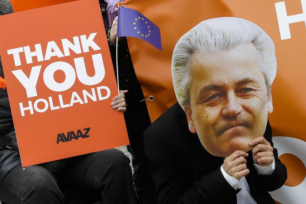 An activist with a mask of Dutch anti-Islam lawmaker Geert Wilders celebrates the election results in the Netherlands in front of the Brandenburg Gate in Berlin, Thursday, March 16, 2017. (Markus Schreiber/AP)