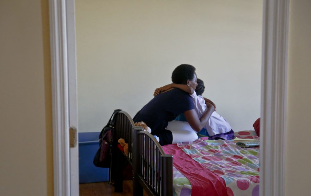 Tonia Handy, left, hugs her youngest child in their Brooklyn shelter in July 2016. (Bebeto Matthews/AP)