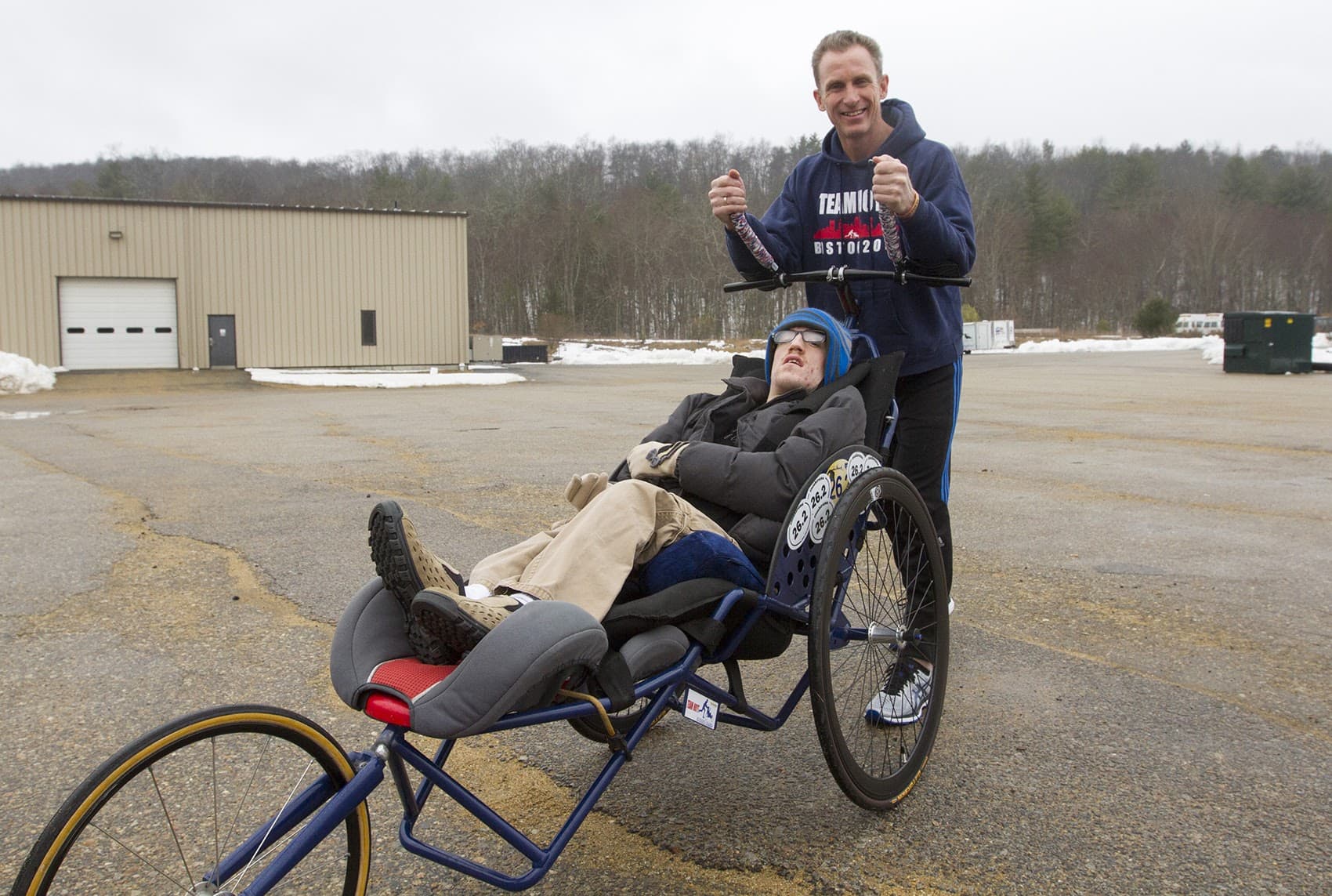 Ted Painter, right, races with Nick Draper using a Team Hoyt Running Chair built by Southbridge Tool and Manufacturing in Dudley. (Joe Difazio for WBUR)