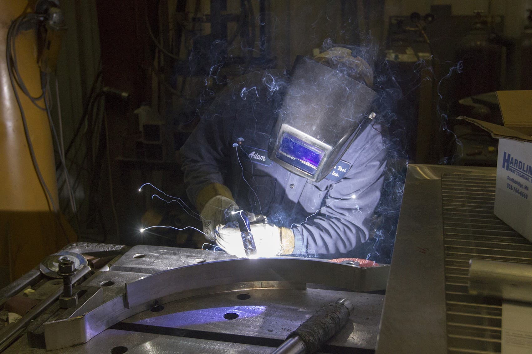 Adam Rathburn, welding a chair at Southbridge Tool and Manufacturing in Dudley where Team Hoyt Running Chairs are made. (Joe Difazio for WBUR)