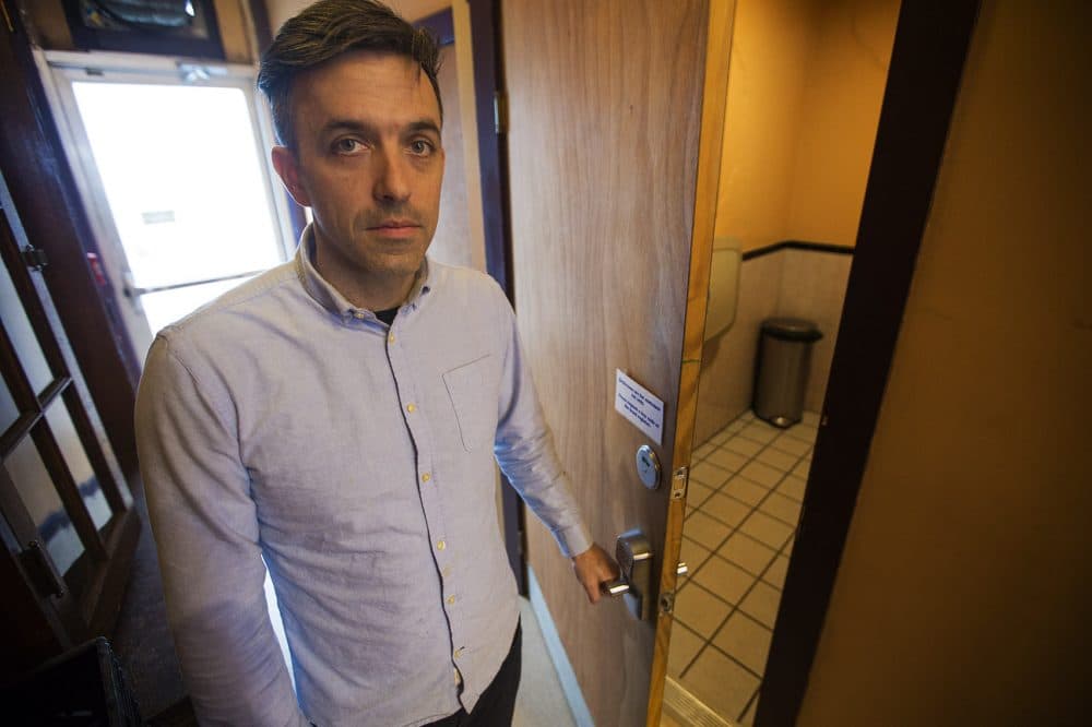 1369 Coffee House owner Josh Gerber opens the bathroom door which has a combination lock given to patrons at the front counter. (Jesse Costa/WBUR)