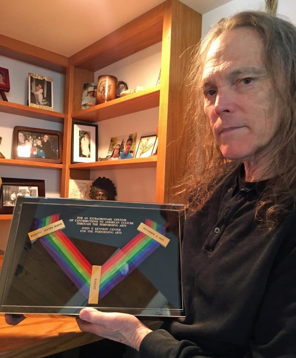 Schmit holds the Kennedy Center Honors medal won posthumously by Eagles bandmate Glenn Frey. (Robin Young/Here &amp; Now)