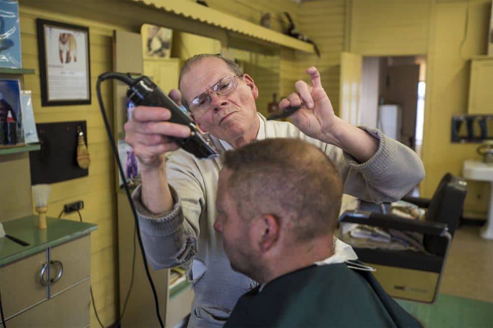 Pete Lareau gives a haircut to Randy Elwell at Pete's barber shop in Townsend, where Lareau has been cutting hair for 58 years. (Jesse Costa/WBUR)