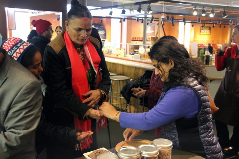 Rita Neopaney, who works as the as a Community Outreach Counselor at AALV, a nonprofit that helps new Americans, hands out chocolate samples on a recent group outing. (Kathleen Masterson/VPR)