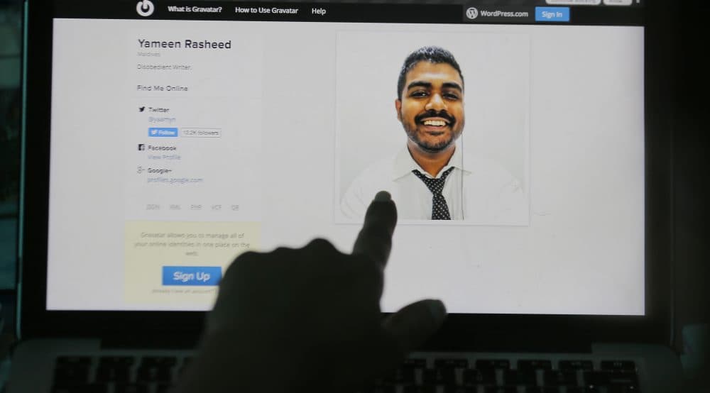 A Sri Lankan woman points to a portrait of Maldivian blogger Yameen Rasheed on his blog "The Daily Panic" in Colombo, Sri Lanka, Sunday, April 23, 2017. Police in the Maldives said in a statement that Rasheed was found Sunday morning with multiple stab wounds in a house in the capital, Male. He died at a hospital. (Eranga Jayawardena/AP)