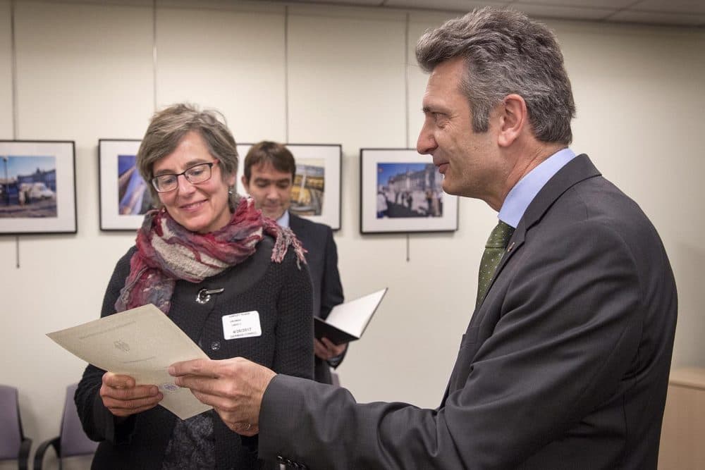 Linda Heuman, 53, receives her certificate of German citizenship from Ralf Horlemann, the German consul general in Boston. (Robin Lubbock/WBUR)