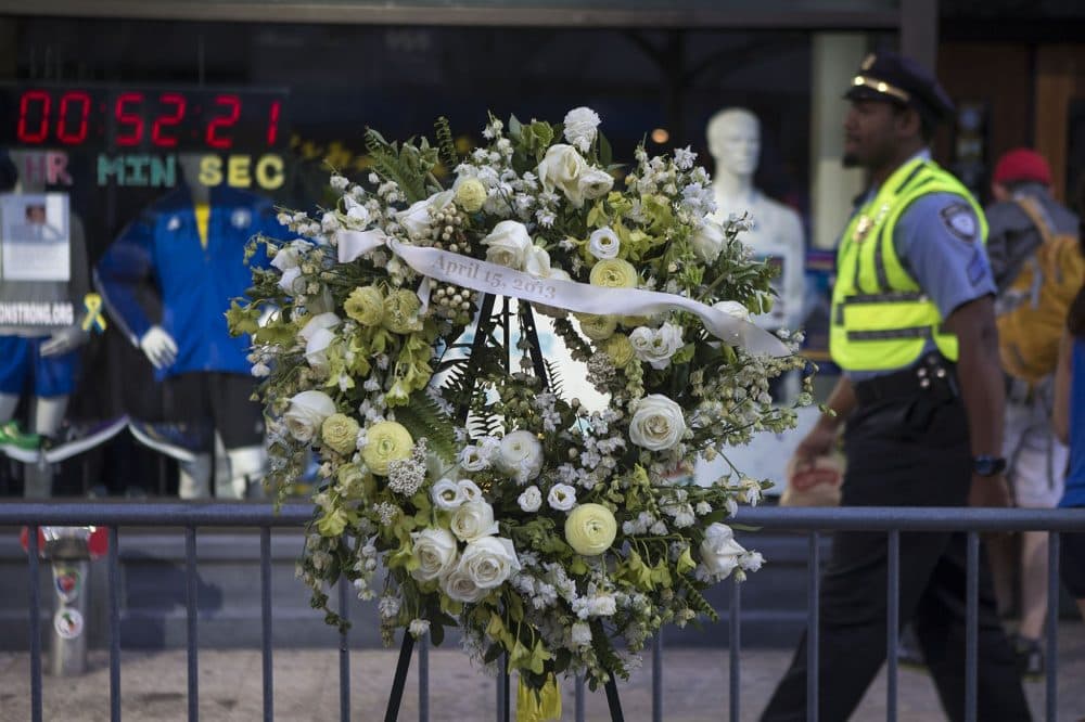 Two wreaths mark the location of the two bombs that went off at the finish line in 2013. This one is set up in front of Marathon Sports. (Jesse Costa/WBUR)