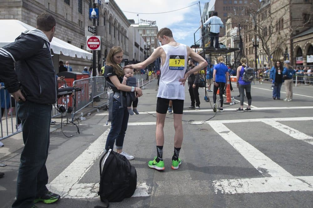 American Galen Rupp, who came in second place in the Elite Men's division, places his hand on the head of his 6-month-old son, Jayden. (Jesse Costa/WBUR)