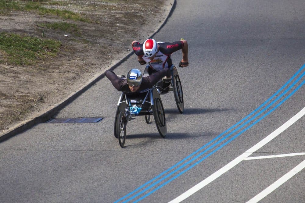 Men's Wheelchair racer Marcel Hug leads Ernst van Dyk by a hair as they head underneath the Mass. Ave. Bridge just before the final stretch of the race. (Jesse Costa/WBUR)