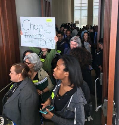 UMass Boston Faculty, staff and students packed a board of trustees meeting Wednesday, protesting academic cuts amid a projected budget deficit. (Max Larkin/WBUR)