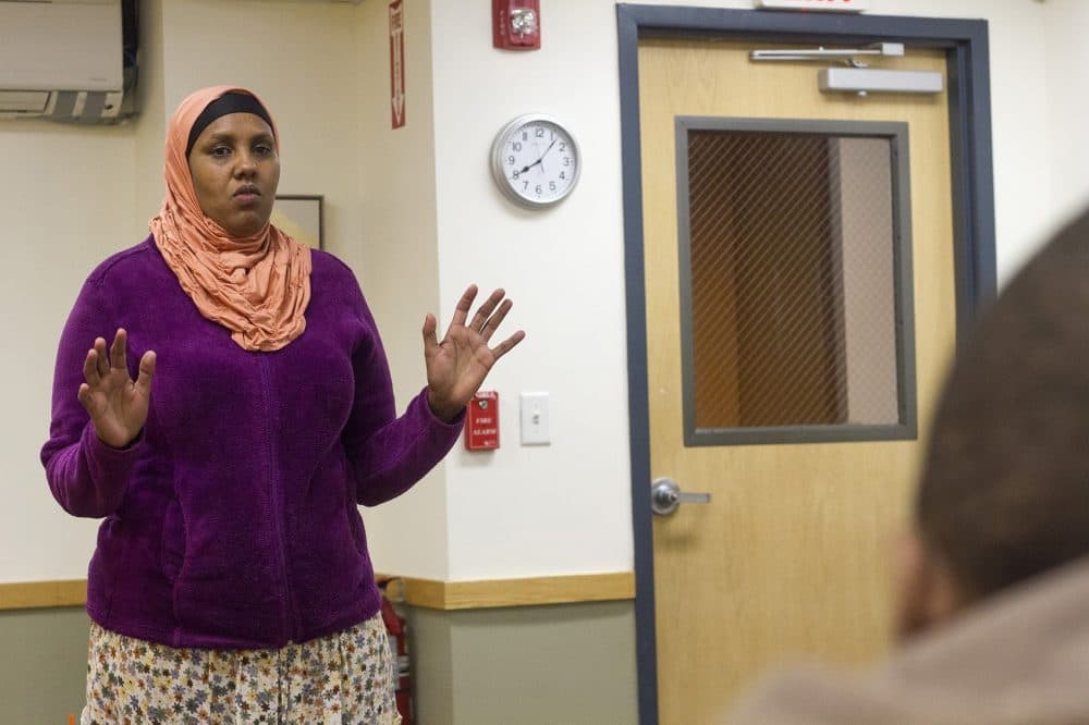 Sulekha Ali, a 37-year-old Somali refugee and mother of five, stands in front of the group and practices telling her own story. (Joe Difazio for WBUR)