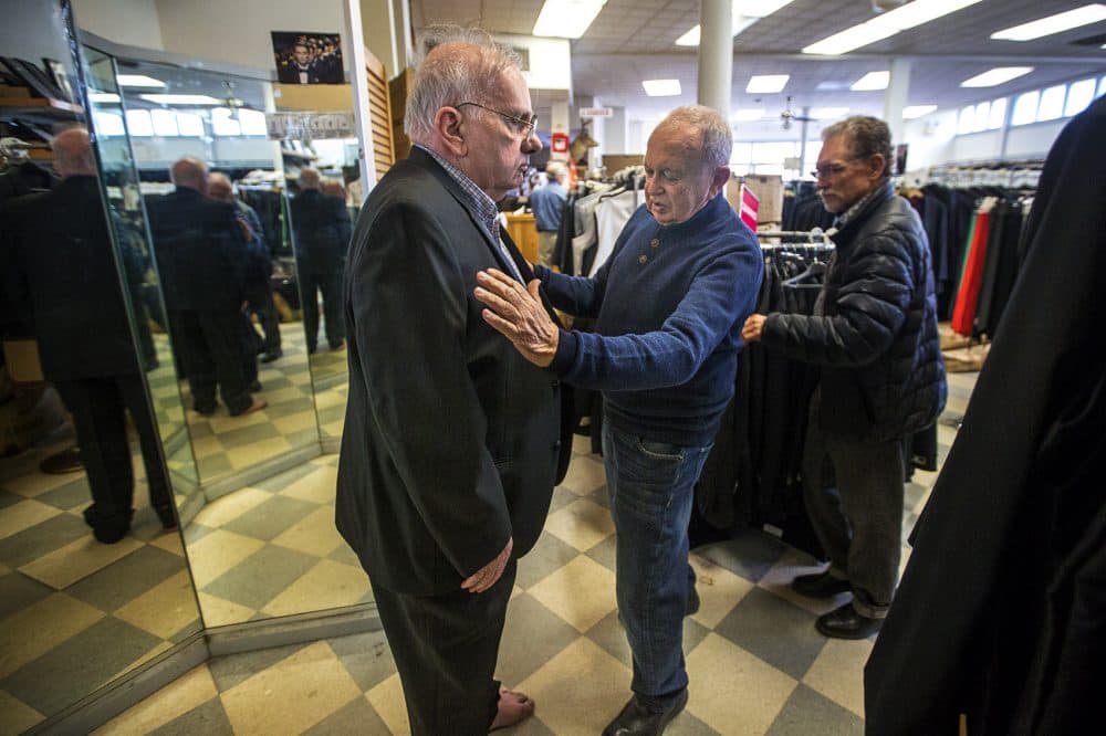 Steve Cauley, of Somerville, gets outfitted by a Keezer's staff member. Keezer’s is classic old school retail, with cardboard boxes lining the walls inside the entrance and all of the store signs handwritten in marker. (Jesse Costa/WBUR)