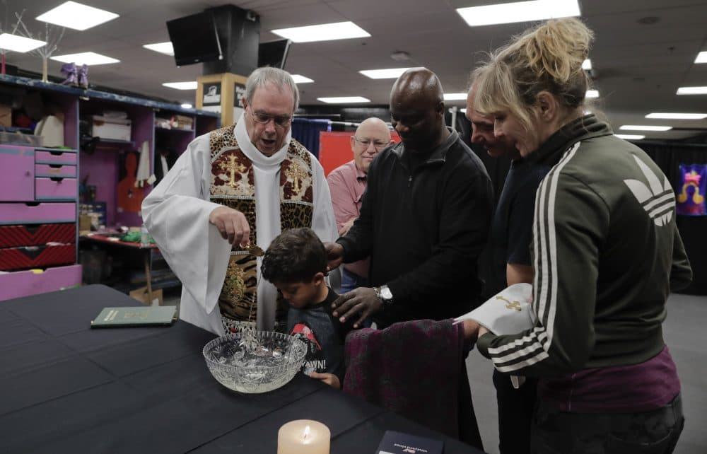 Rev. Jerry Hogan, left, leads a baptism service for 6-year-old Eddie Strickland, the son of Jimmie Strickland, a member of the crew before a Ringling Bros. circus show on May 4. (Julie Jacobson/AP)