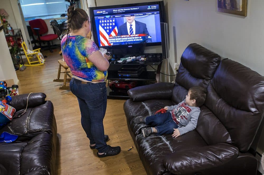 Rosa Benitez changes the channel on the television for her 2-year-old son Brandon. (Jesse Costa/WBUR)