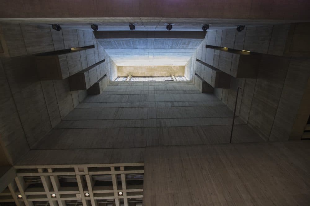 A shaft of sunlight pours in through the concrete walls of Boston City Hall's lobby. (Jesse Costa/WBUR)