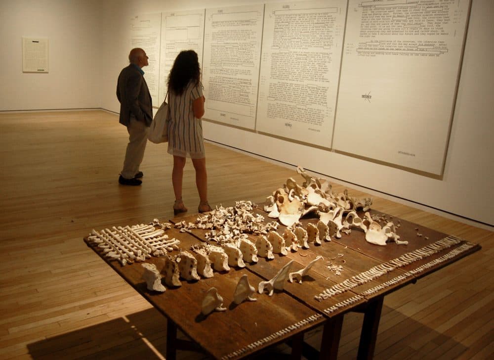 Jenny Holzer's installation at MASS MoCA includes tables of actual human bones and screenprints of declassified American military documents recording prisoner abuse. (Greg Cook/WBUR)