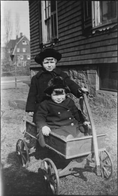 Joseph P. Kennedy, Jr., and John F. Kennedy ride in an Express wooden coaster wagon outside the Kennedy family home on Beals Street in Brookline, Mass. (Courtesy JFK Library and Museum in Boston)