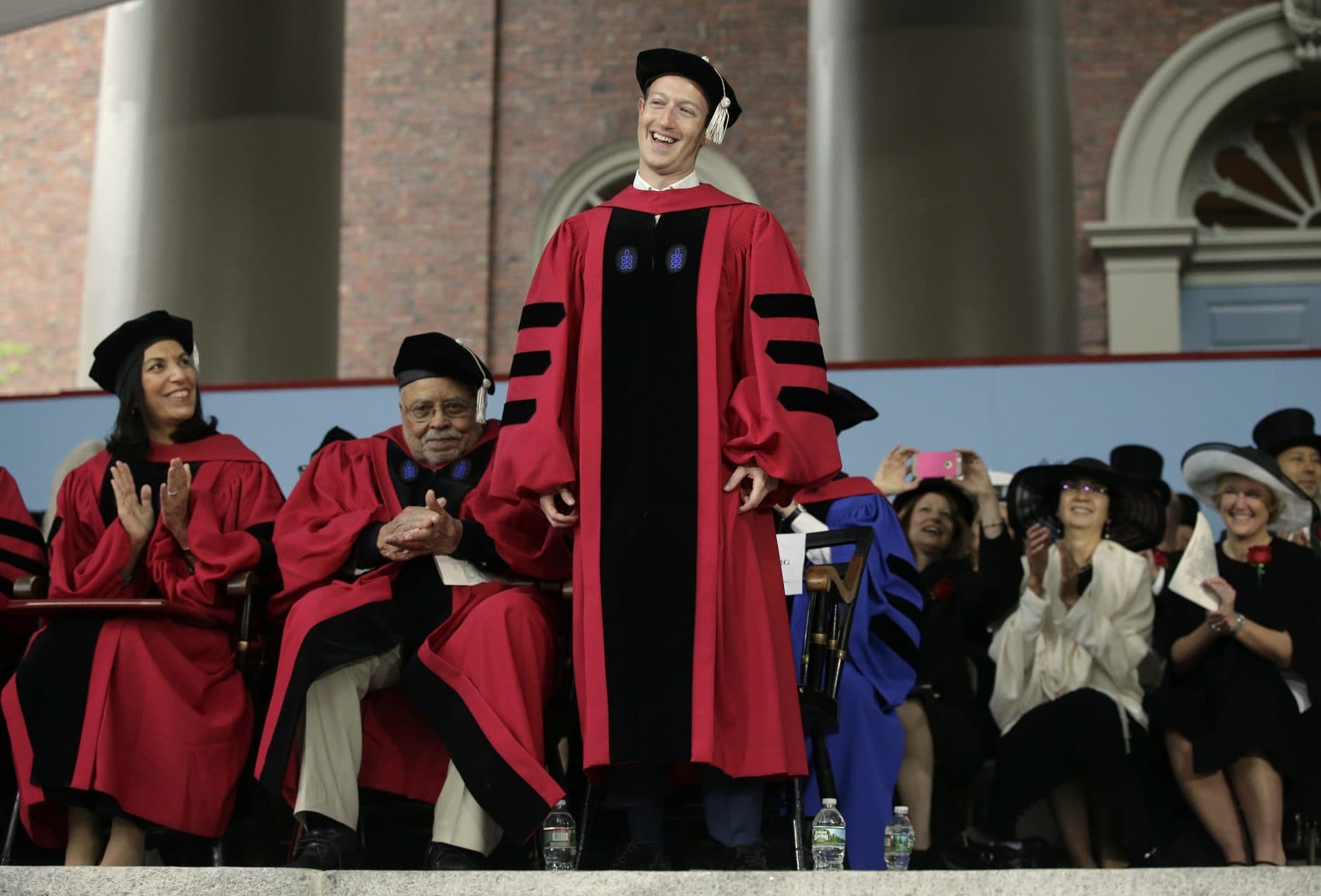 Facebook CEO and Harvard dropout Mark Zuckerberg, center, smiles as he is introduced before being presented with an honorary Doctor of Laws degree during Harvard University commencement exercises Thursday. (Steven Senne/AP)