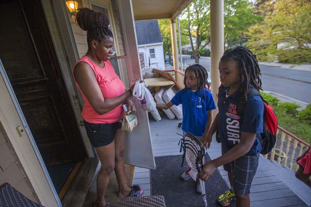 Beverly Hiliare gives her sons snacks for their long ride home from school. (Jesse Costa/WBUR)