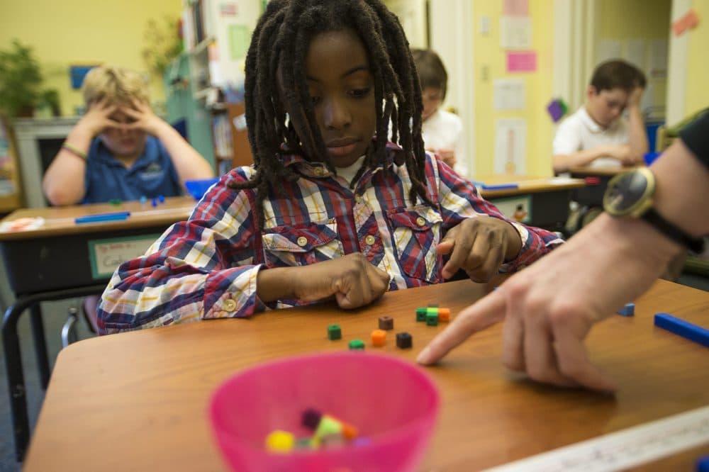Along with the rest of his class at the Landmark School, 9-year-old Harrison Hiliare does math problems with blocks to help him visualize units. (Jesse Costa/WBUR)
